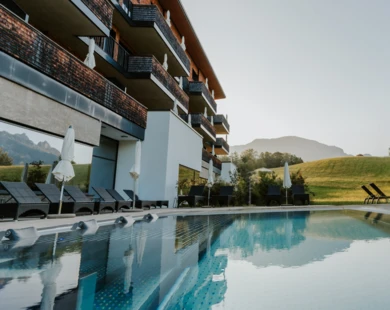 Ein Blick auf den Pool des Hotel Klosterhof, umgeben von einer malerischen Landschaft in Bayerisch Gmain. Entspannung im Wellnesshotel.