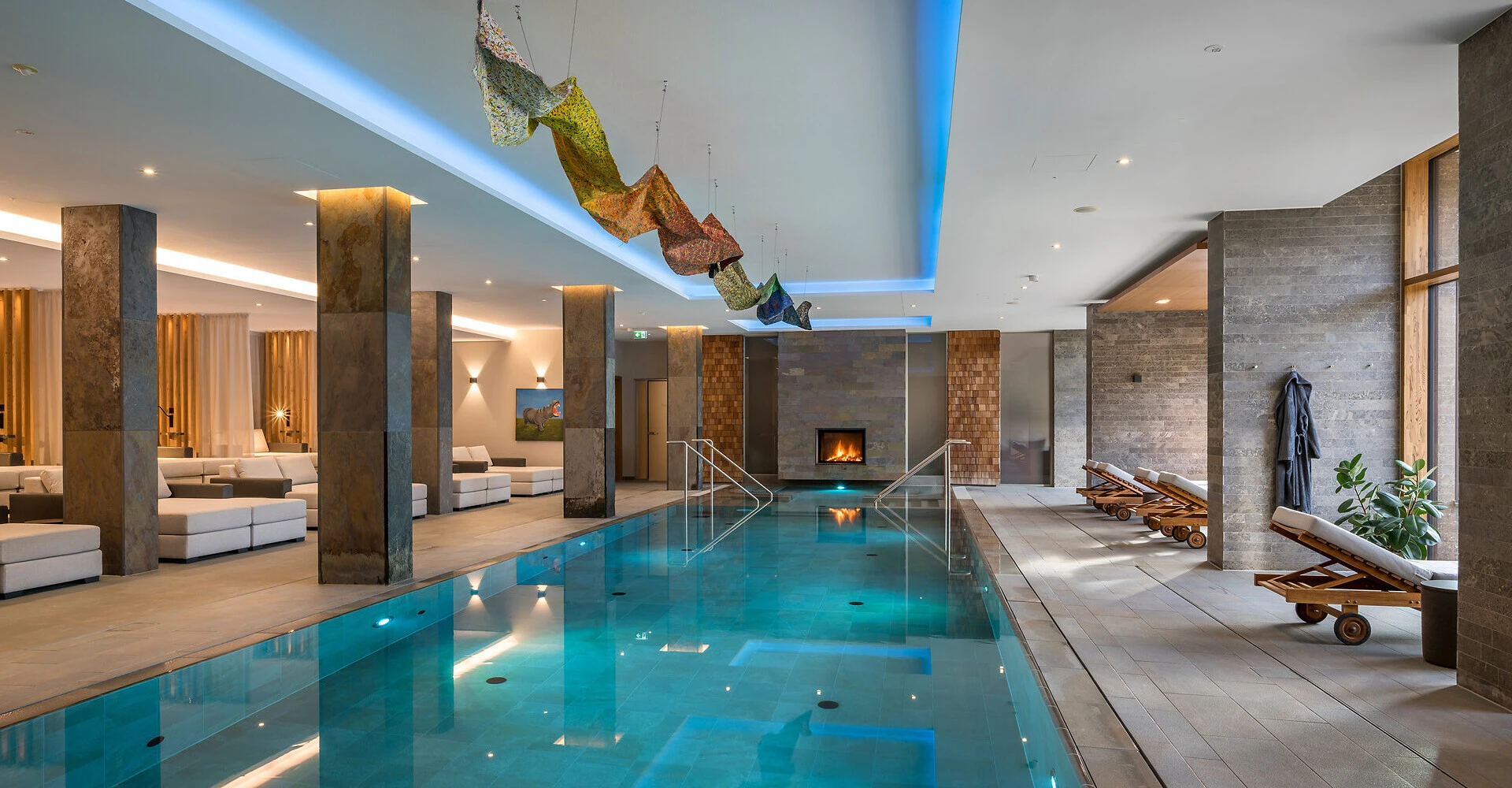 Indoor-Hallenbad mit Kaminlounge im Alpine Hideaway & Spa Hotel Klosterhof in Bayerisch Gmain.