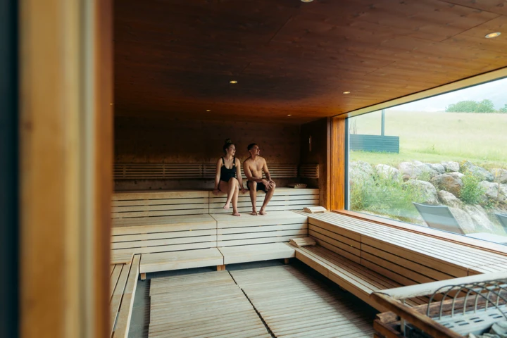 Junges Pärchen beim gemeinsamen Baden im Indoor-Pool des romantischen Hotels Klosterhof in Bayern.