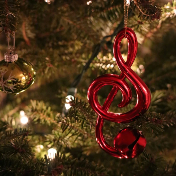 Rote Violinschlüssel-Ornament an einem Weihnachtsbaum mit Lichtern im Hotel Klosterhof.