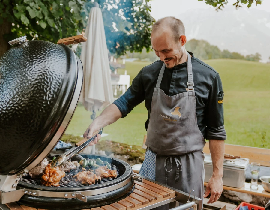 Chef grilling meat outdoors at Hotel Klosterhof.